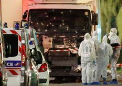 French police forces and forensic officers stand next to a truck July 15, 2016 that ran into a crowd celebrating the Bastille Day national holiday on the Promenade des Anglais killing at least 75 people in Nice, France, July 14.