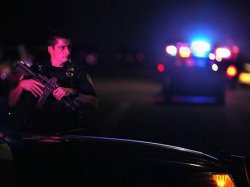 A San Diego Police officer helps to secure the scene near the corner of 39th Street and Boston Avenue in San Diego near where two San Diego Police officers were shot Thursday night, July 28, 2016.