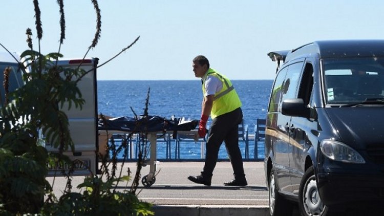 A forensic expert evacuates a dead body on the Promenade des Anglais seafront in the French Riviera city of Nice on July 15, 2016, after a gunman smashed a truck into a crowd of revellers celebrating Bastille Day, killing at least 84 people.