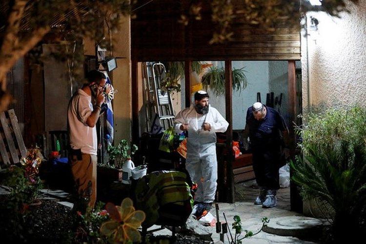 Members of the Zaka Rescue and Recovery team work in the home where three Israelis were killed in a stabbing attack yesterday in the Jewish settlement of Neve Tsuf, in the occupied West Bank, July 22, 2017. REUTERS/Amir Cohen