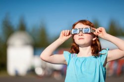 Girl wearing solar eclipse glasses