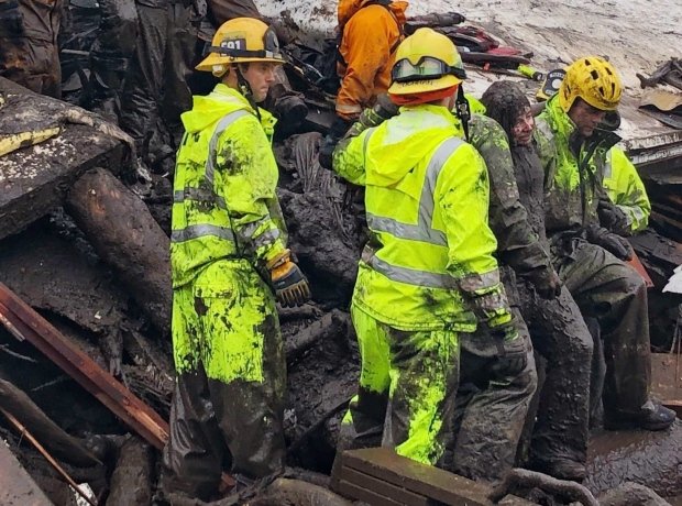 Firefighters successfully rescue a 14-year-old girl, right, after she was trapped for hours inside a destroyed home in Montecito on Tuesday. (Mike Eliason/Santa Barbara County Fire Dept. via Associated Press)