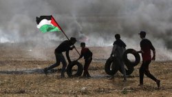 Protestors carry Palestinian flag and tires to Gaza/Israel border