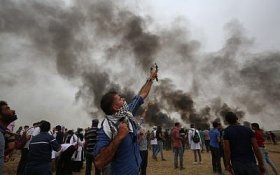 A Palestinian man uses a slingshot during weekly protests along the Gaza border near the city of Khan Younis on May 4, 2018. (Said Khatib/AFP)