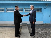 Kim Jong-un and Moon Jae-in standing on either side of the border between North Korea and South Korea