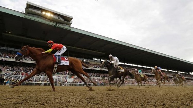 Justify (1), with jockey Mike Smith up, crosses the finish line to win the 150th running of the Belmont Stakes horse race and the Triple Crown on Saturday in Elmont, N.Y. (AP Photo/Julio Cortez)