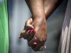 Relatives of the Charleston church shooting victims hold hands outside a bond hearing for Dylann Roof.