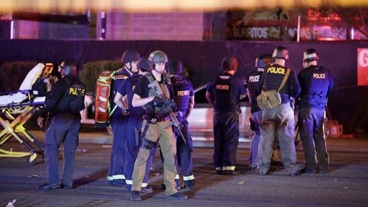 Police officers stand at the scene of a shooting near the Mandalay Bay resort and casino on the Las Vegas Strip, Monday, Oct. 2, 2017, in Las Vegas.  (AP Photo/John Locher)