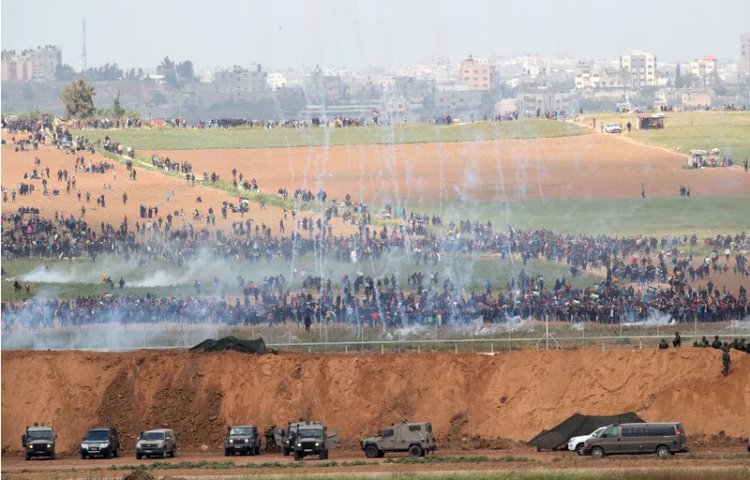 Palestinians protest in Gaza as Israeli soldiers keep watch from across the barrier fence on Friday. (Jack Guez / AFP � Getty Images)